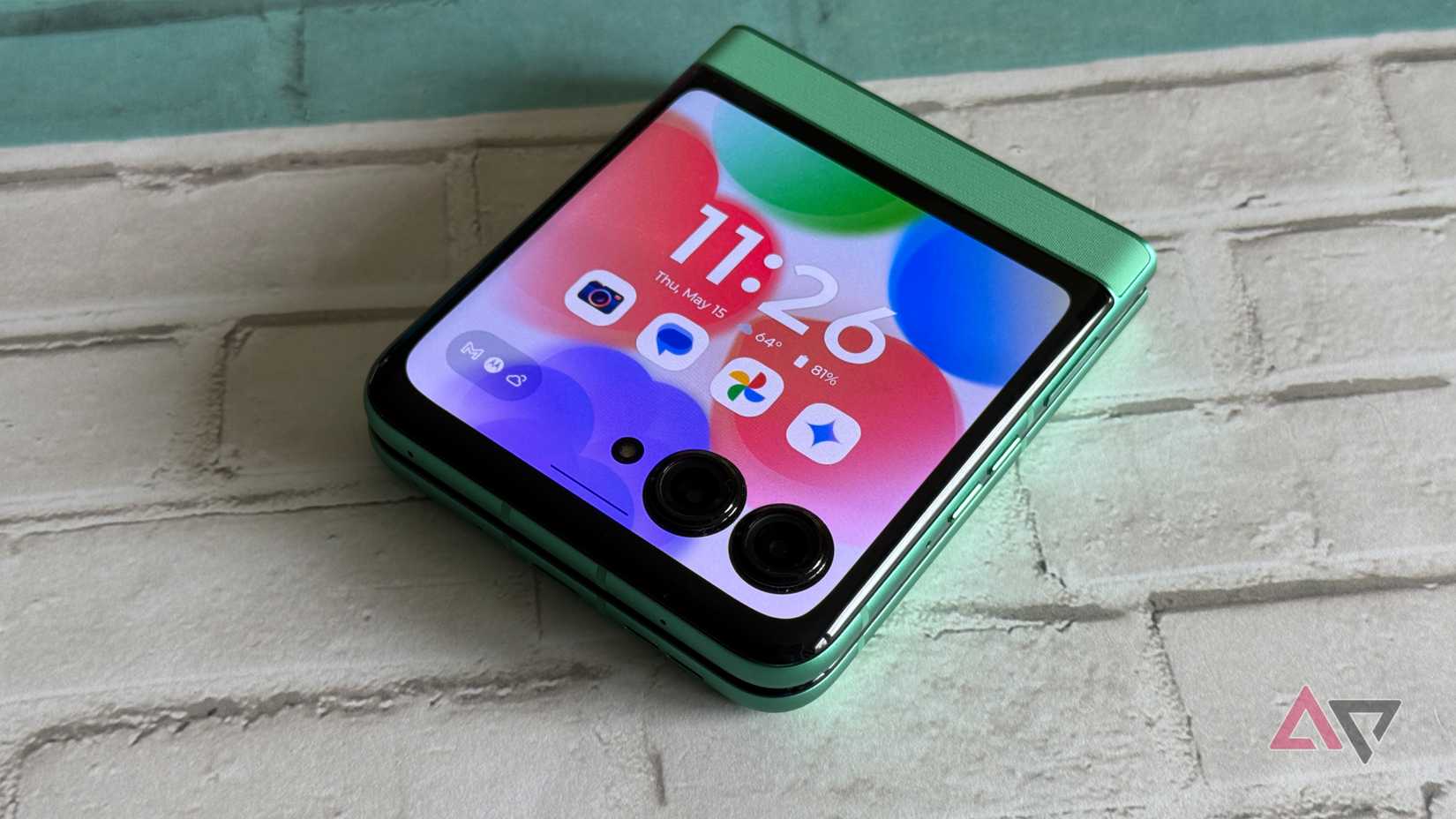 The Google Pixel Fold on a wicker table with a notebook and pen next to it.