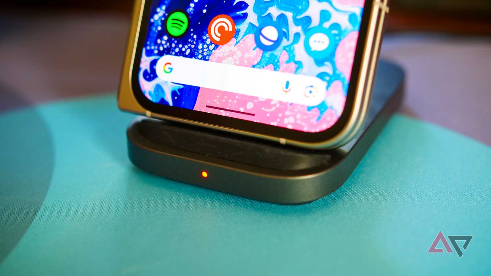 A hand holding a phone with the logos of some streaming services on the screen and several coins.