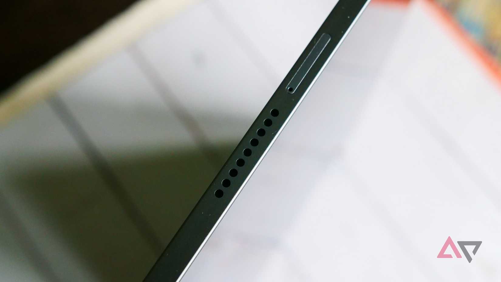 A tablet with NotebookLM website opened laying on a table with a physical notebook beneath it